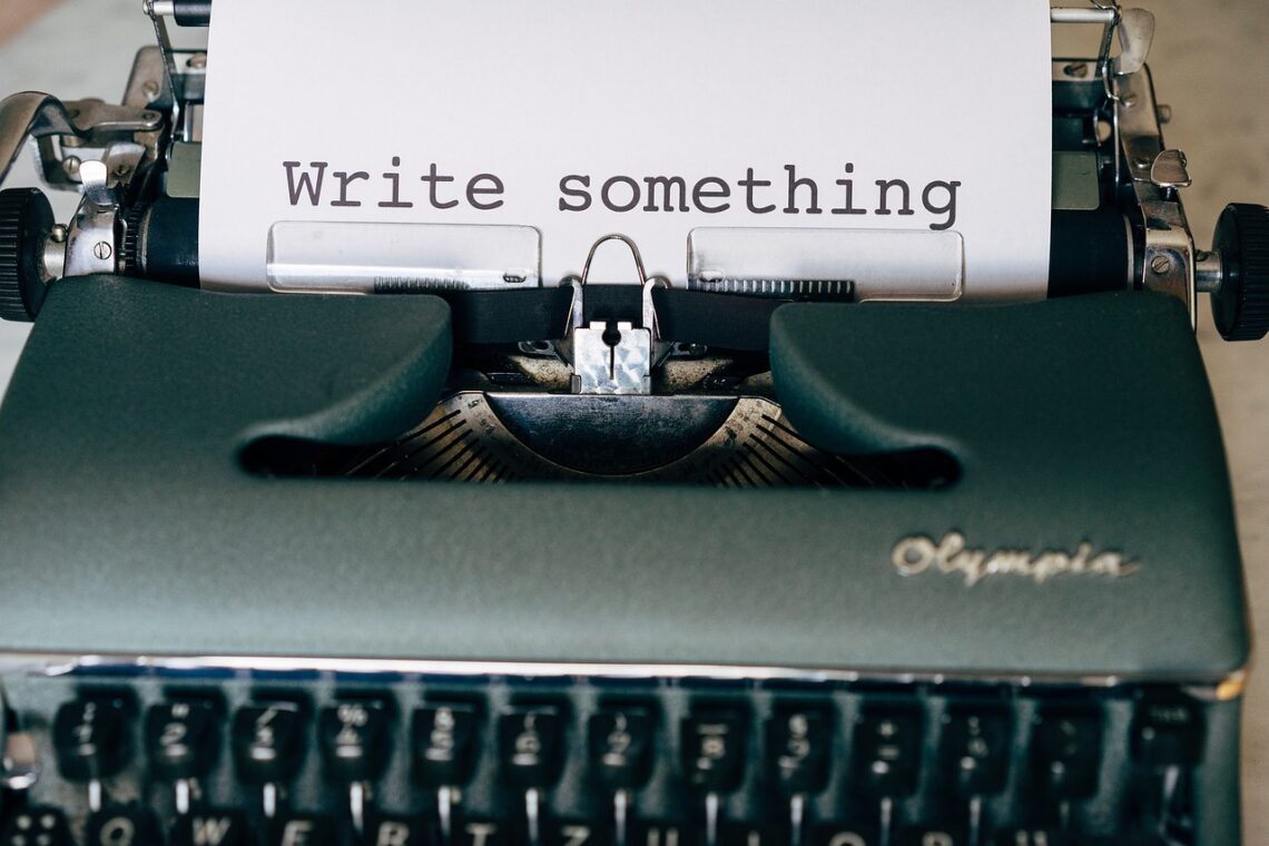 Vintage typewriter with a sheet of paper that reads “Write something.”