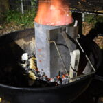 Season Is What We Put on Food Charcoal grill with a chimney starter lit at night during a late-night cookout